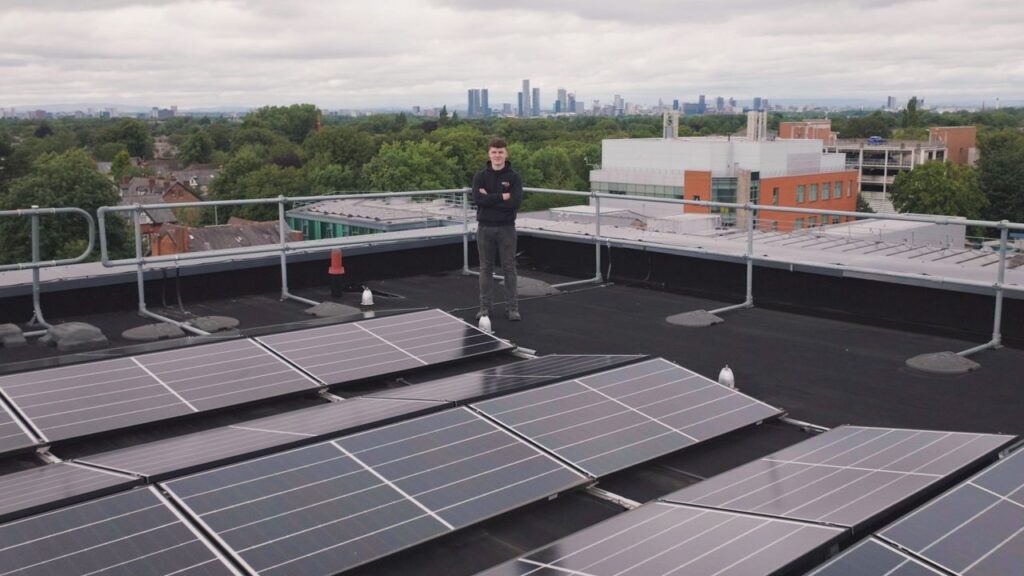 Person on a rooftop with solar panels showcasing renewable energy and technology.