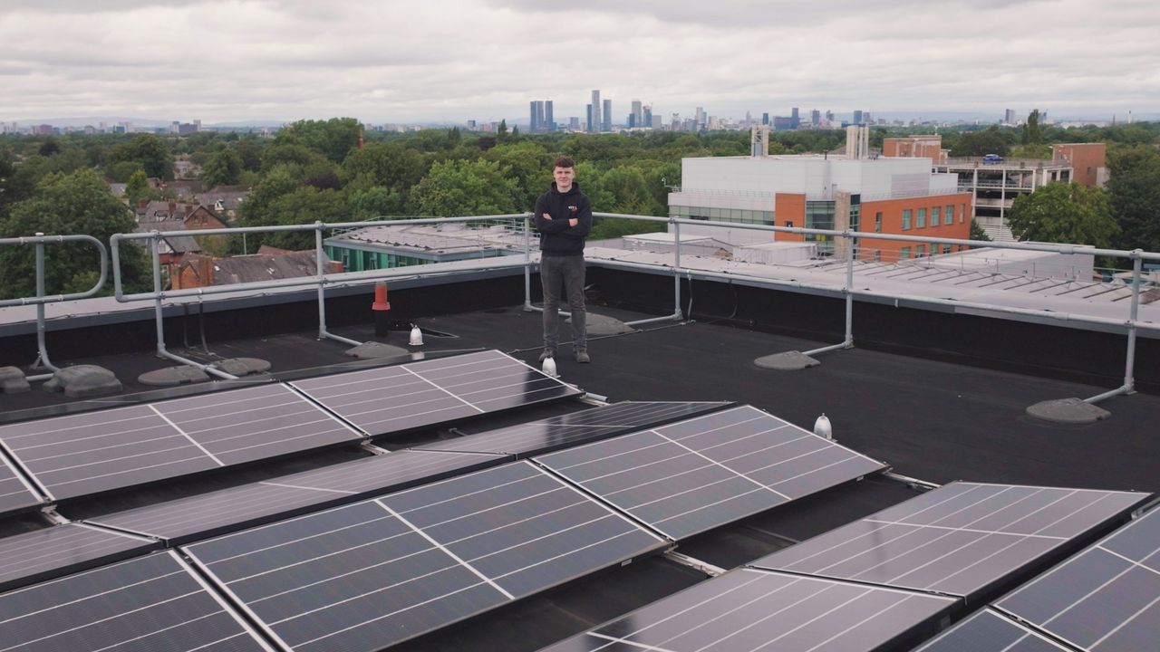 Person on a rooftop with solar panels showcasing renewable energy and technology.